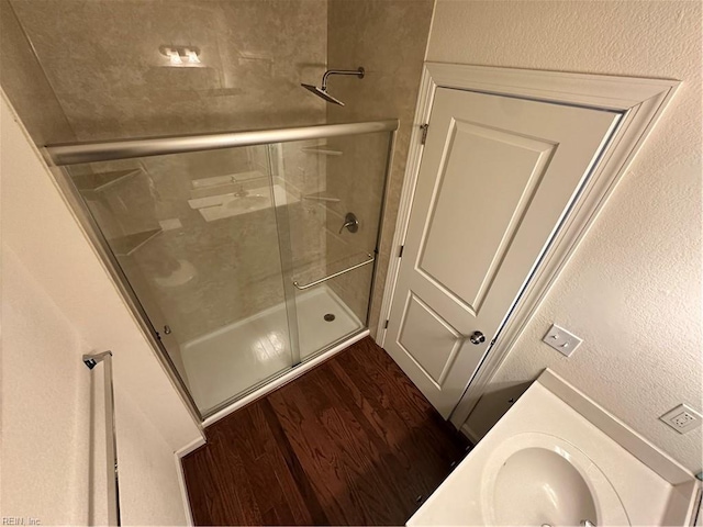 bathroom featuring wood-type flooring, vanity, and walk in shower