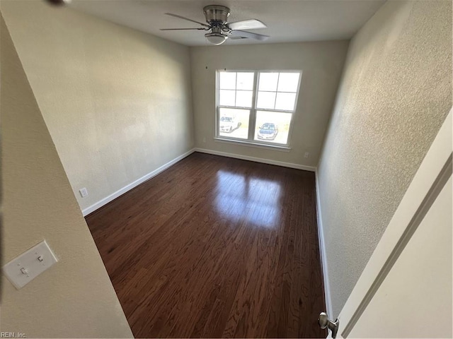 spare room featuring dark hardwood / wood-style flooring and ceiling fan