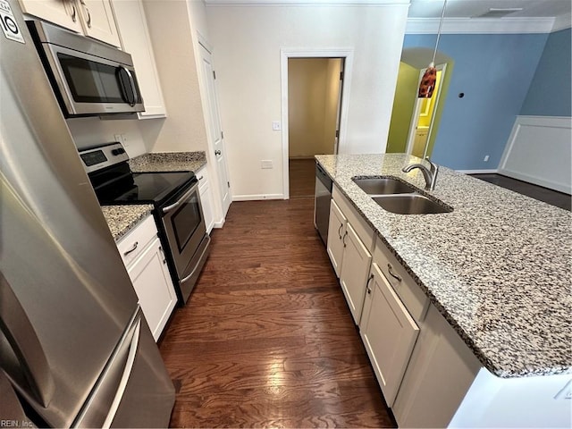 kitchen with light stone countertops, stainless steel appliances, sink, white cabinets, and dark hardwood / wood-style floors