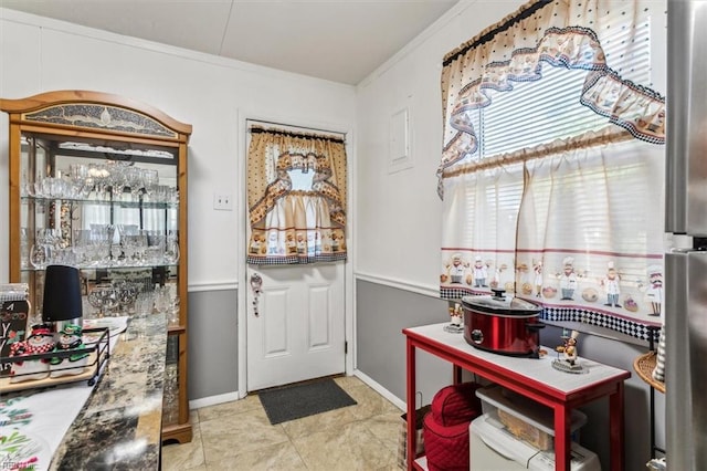 doorway featuring light tile patterned floors and ornamental molding