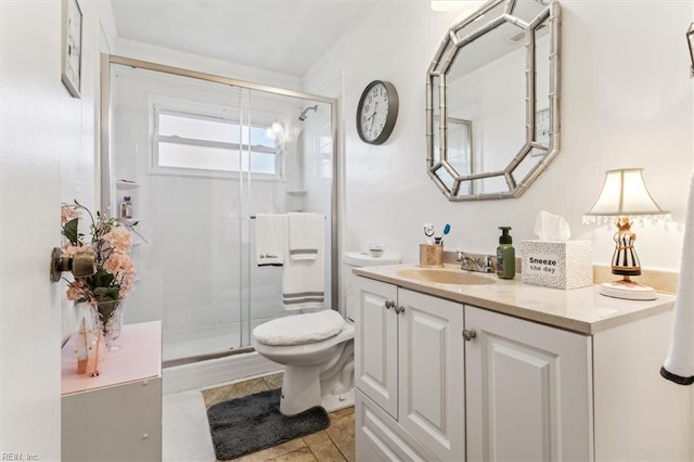 bathroom featuring tile patterned floors, vanity, toilet, and walk in shower