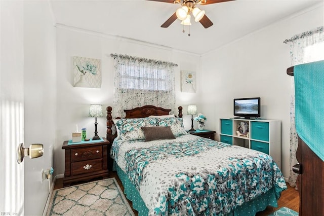 bedroom featuring ceiling fan, light wood-type flooring, and crown molding