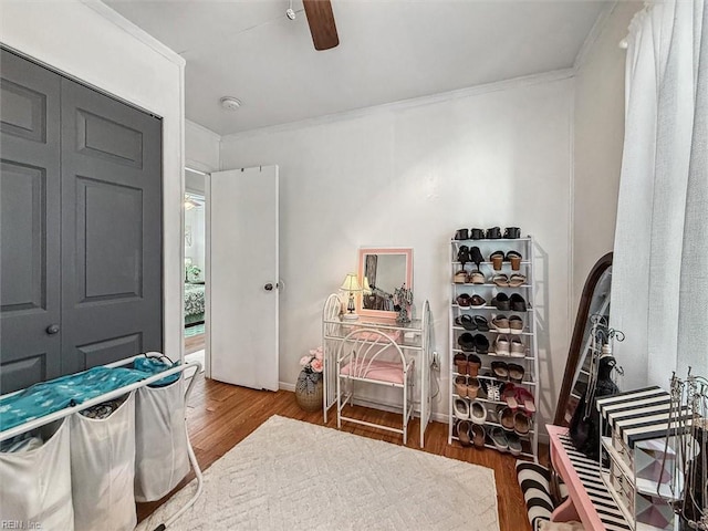 bedroom featuring a closet, ceiling fan, crown molding, and hardwood / wood-style flooring