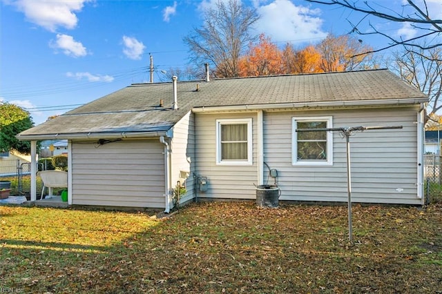 rear view of house featuring a lawn and cooling unit