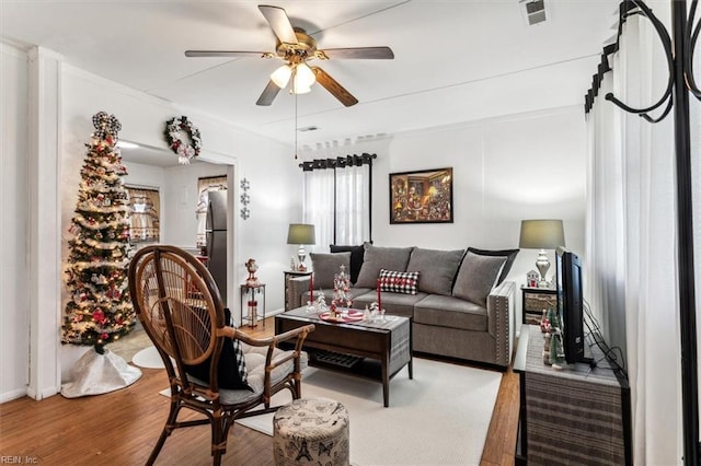 living room with wood-type flooring and ceiling fan