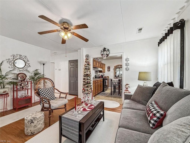 living room featuring ceiling fan and light hardwood / wood-style floors