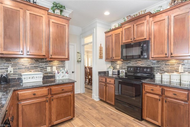 kitchen with light wood-type flooring, tasteful backsplash, dark stone counters, and black appliances