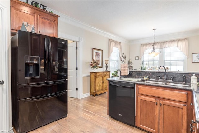 kitchen featuring decorative light fixtures, black appliances, sink, light wood-type flooring, and ornamental molding