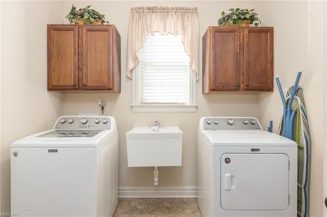 laundry area with cabinets, separate washer and dryer, a healthy amount of sunlight, and sink