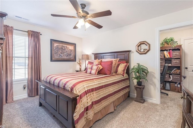 carpeted bedroom featuring ceiling fan and multiple windows