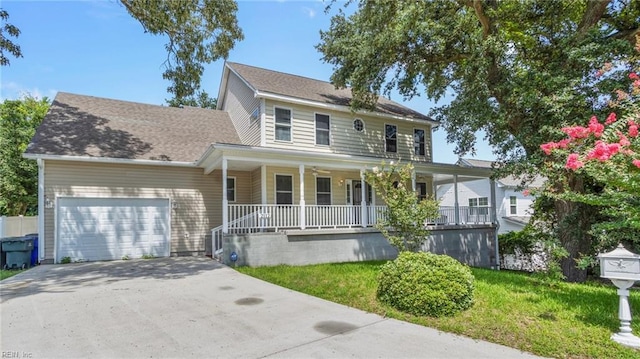 view of front of house featuring covered porch, a garage, and a front yard