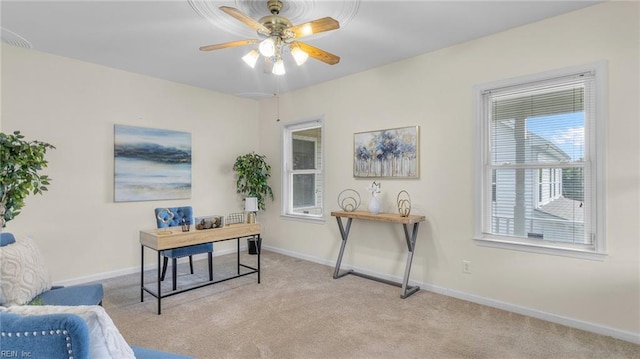 carpeted home office featuring ceiling fan