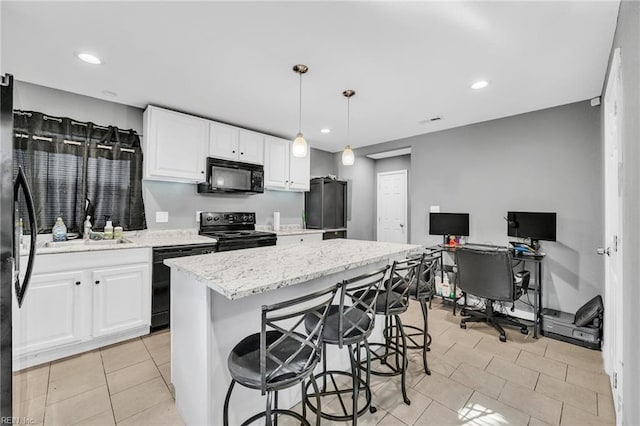 kitchen featuring pendant lighting, black appliances, white cabinets, sink, and a kitchen island