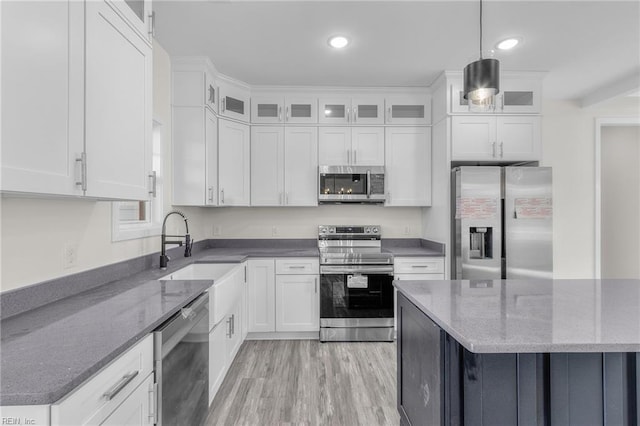 kitchen featuring pendant lighting, white cabinetry, sink, and appliances with stainless steel finishes