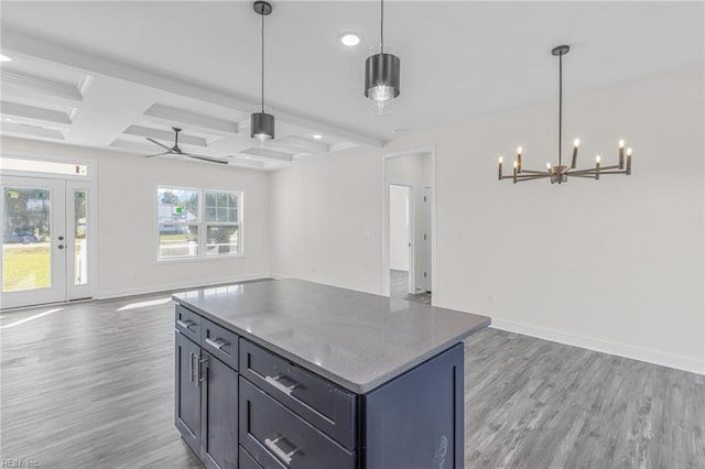 kitchen with ceiling fan with notable chandelier, pendant lighting, light hardwood / wood-style flooring, beamed ceiling, and a center island