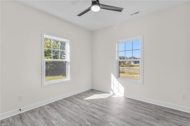 spare room featuring hardwood / wood-style flooring, plenty of natural light, and ceiling fan