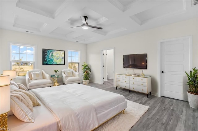 bedroom featuring coffered ceiling, light hardwood / wood-style flooring, ceiling fan, ornamental molding, and beamed ceiling