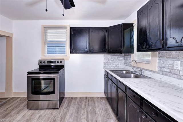 kitchen with tasteful backsplash, electric stove, sink, and light wood-type flooring