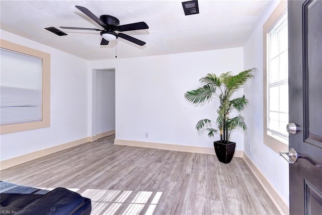 spare room featuring a wealth of natural light, light hardwood / wood-style flooring, and ceiling fan