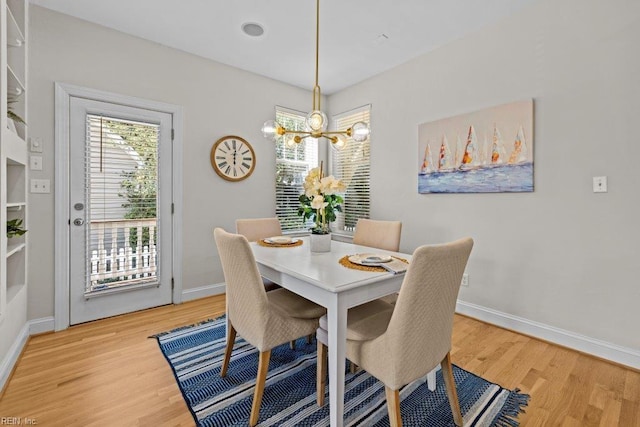 dining room with hardwood / wood-style flooring and a notable chandelier