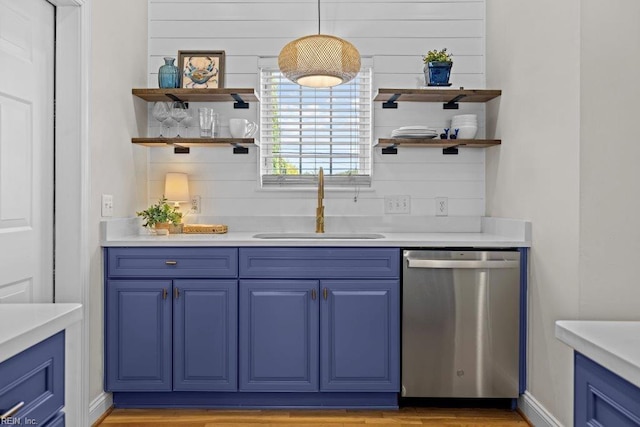 bar with dishwasher, decorative light fixtures, blue cabinetry, and sink