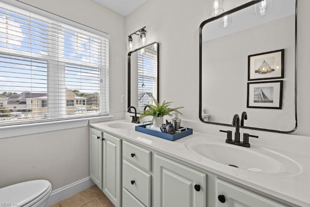 bathroom with toilet, vanity, and tile patterned floors