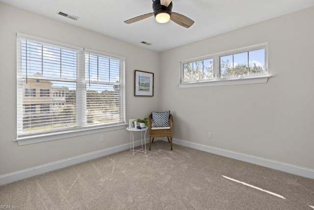 living area featuring light colored carpet, plenty of natural light, and ceiling fan