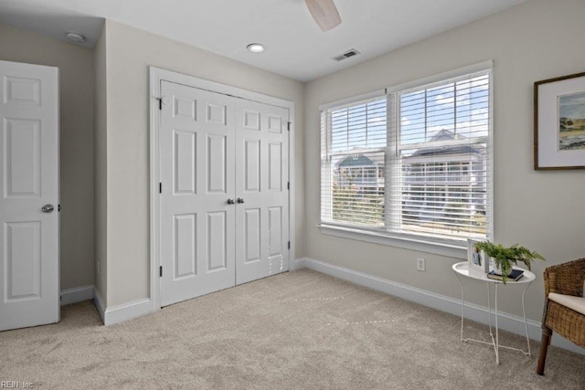 carpeted bedroom with ceiling fan and a closet