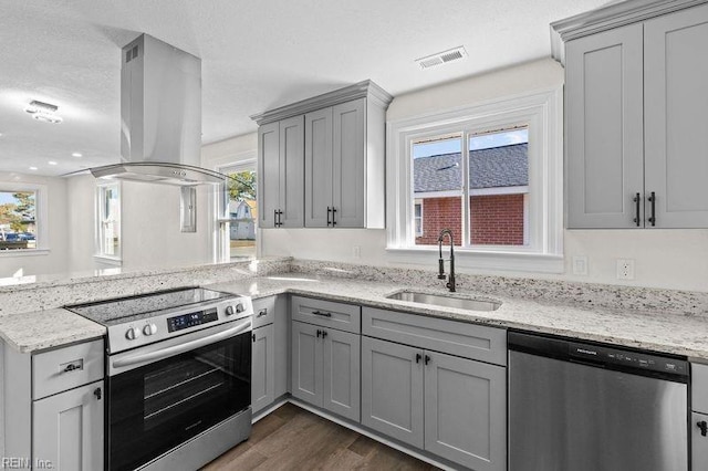 kitchen with island range hood, sink, stainless steel appliances, and a wealth of natural light