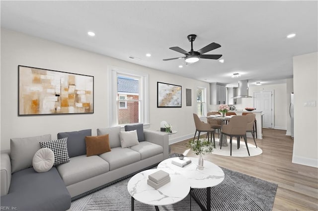 living room with ceiling fan and light hardwood / wood-style floors