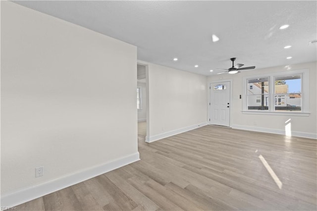 unfurnished living room featuring ceiling fan and light wood-type flooring