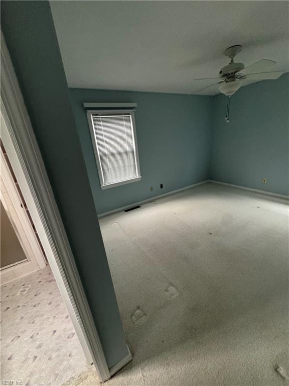 empty room with carpet flooring, vaulted ceiling, and ceiling fan