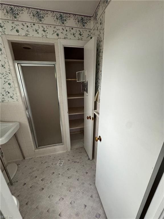 bathroom with walk in shower and tile walls