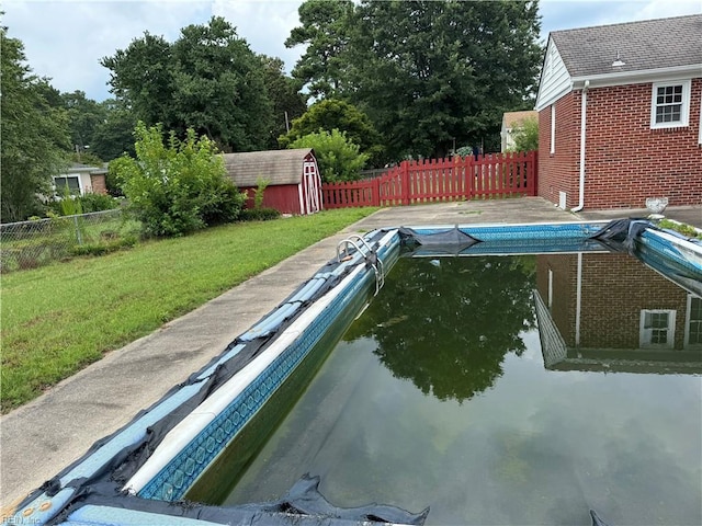 view of pool featuring a yard and a storage unit