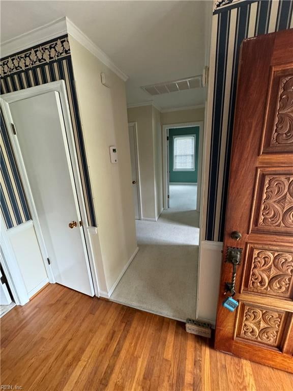 hall featuring light hardwood / wood-style floors and crown molding