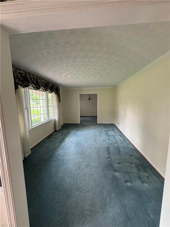 spare room featuring dark colored carpet and a textured ceiling