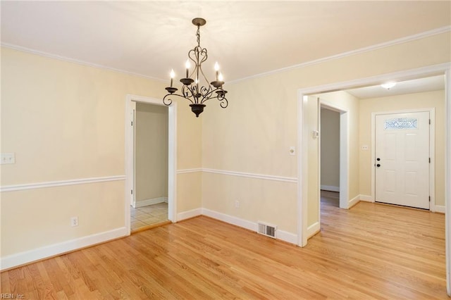 interior space featuring a chandelier, light wood-type flooring, and crown molding