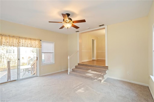 unfurnished living room featuring light carpet and ceiling fan