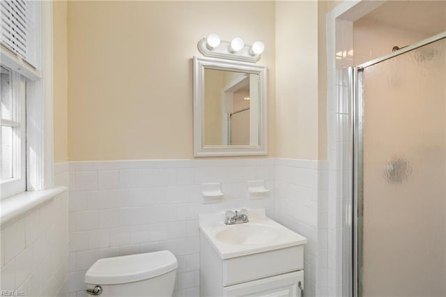 bathroom featuring vanity, toilet, an enclosed shower, and tile walls