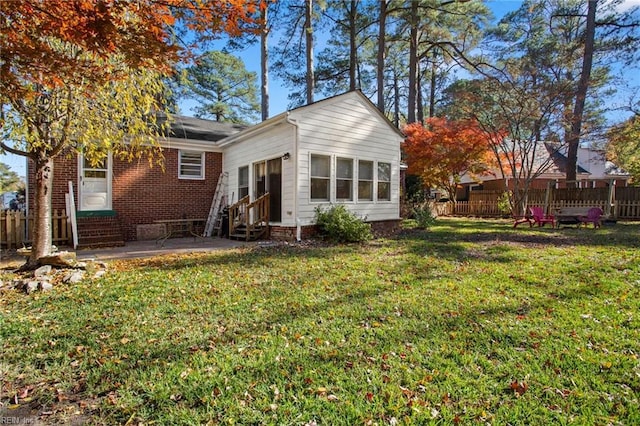 rear view of house featuring a patio area and a yard