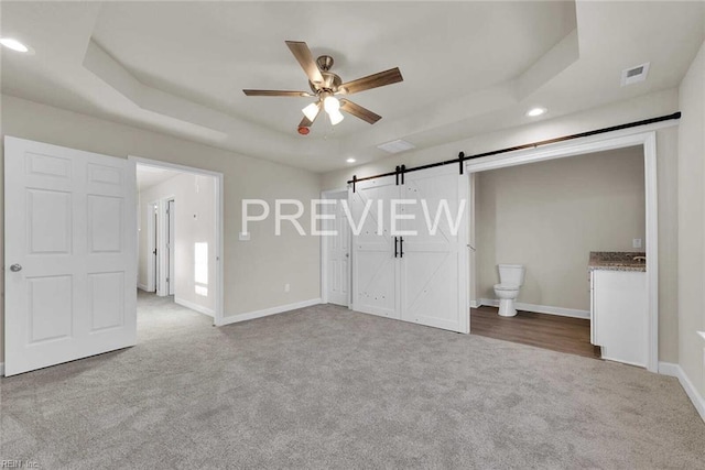 interior space with a barn door and ceiling fan