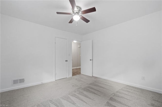 carpeted spare room featuring ceiling fan