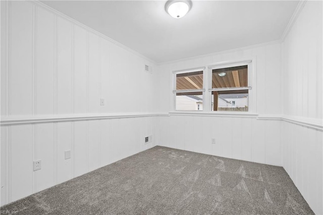 carpeted spare room featuring crown molding