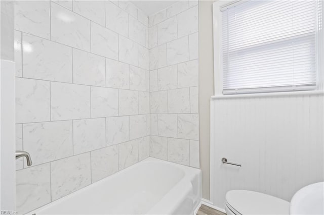 bathroom with tiled shower / bath and toilet