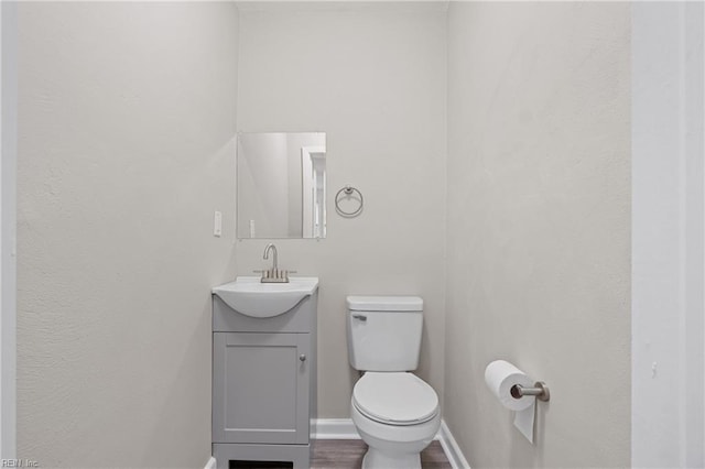 bathroom featuring hardwood / wood-style floors, vanity, and toilet