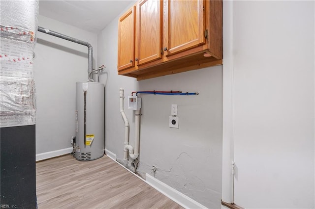 laundry room with light hardwood / wood-style flooring, cabinets, gas water heater, and hookup for an electric dryer