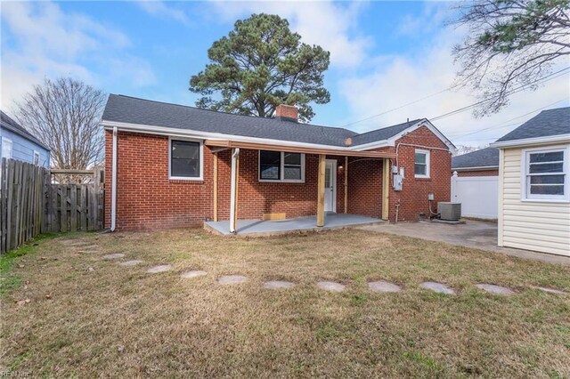 rear view of property featuring a patio and a lawn