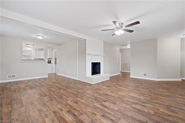 unfurnished living room with ceiling fan, wood-type flooring, and a fireplace