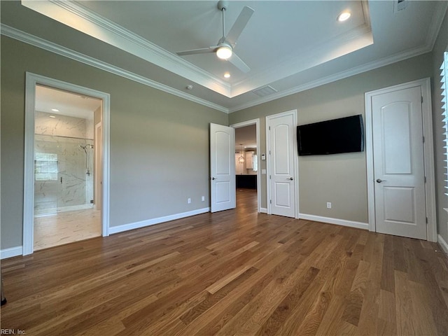 unfurnished bedroom featuring ceiling fan, crown molding, dark wood-type flooring, and a tray ceiling