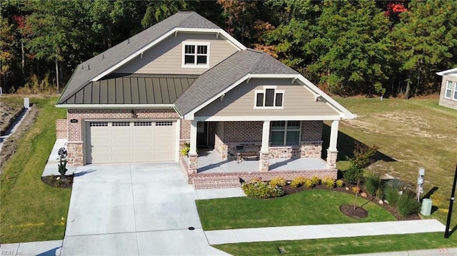 craftsman inspired home with a garage, covered porch, and a front yard